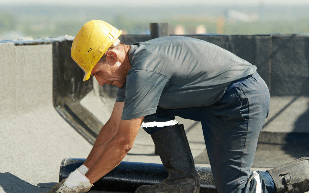 Roofer on a commercial roof replacing commerical roof damage in the summer.