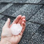 Person holding a hail core over a residential roof looking for hail damage.